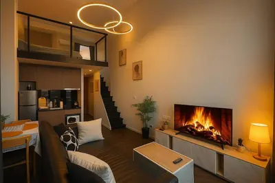 a living room with a fireplace and a couch at Incredible Loft with High Ceiling in Bangkok