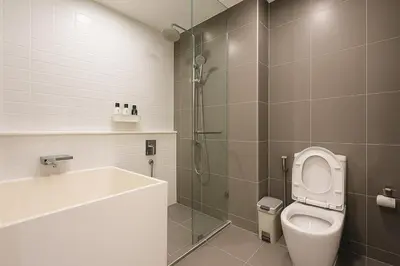 a bathroom with a shower and a toilet and a tub at Incredible Loft with High Ceiling in Bangkok