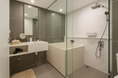 a bathroom with a glass shower and a sink at Incredible Loft with High Ceiling in Bangkok