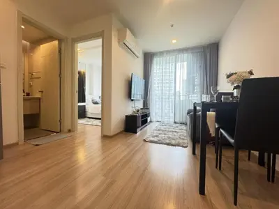a living room with a dining room table and a living room with a room at Cozy&Bright apartment -Onnut BTS in Bangkok