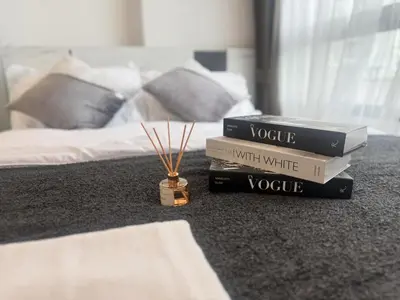 a stack of books sitting on the floor next to a bed at Cozy&Bright apartment -Onnut BTS in Bangkok