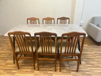a dining room table with four wooden chairs and a white marble table at Siam Place - In the Heart of Bangkok in Bangkok