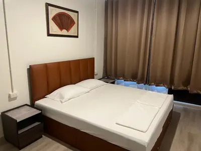 a small bedroom with a bed with white sheets at Siam Place - In the Heart of Bangkok in Bangkok