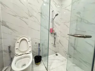 a bathroom with a toilet and a glass shower at Noble Bangkok Condo in Bangkok