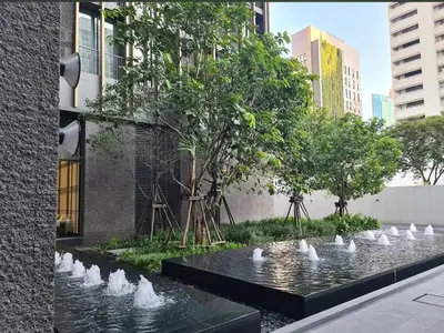 a water fountain with white birds in a city at Noble Bangkok Condo in Bangkok