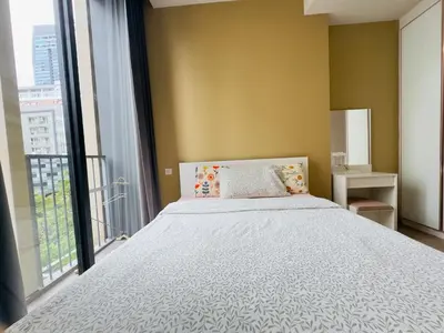 a bedroom with a bed and a large window at Noble Bangkok Condo in Bangkok