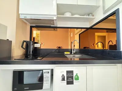 a kitchen with a sink and a microwave at Ekkamai Bangkok Condo in Bangkok
