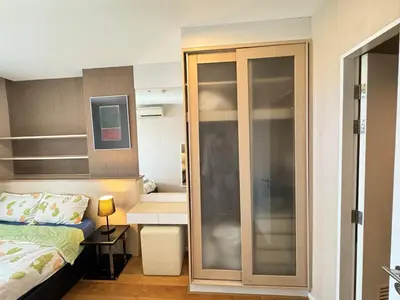 a bedroom with a bed and a sliding glass door at Ekkamai Bangkok Condo in Bangkok