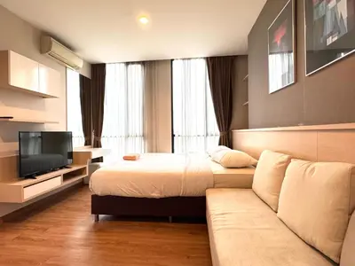 a hotel room with a bed and a couch at Ekkamai Bangkok Condo in Bangkok