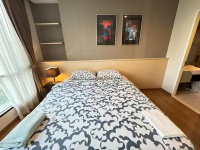 a bedroom with a bed with a blue and white comforter at Ekkamai Bangkok Condo in Bangkok