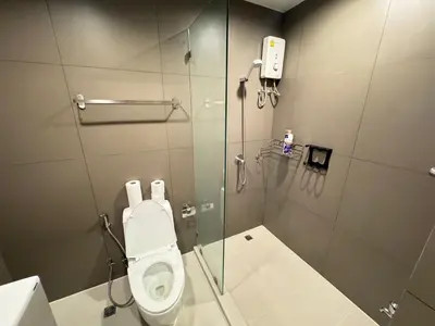 a bathroom with a glass shower with a toilet at Ekkamai Bangkok Condo in Bangkok