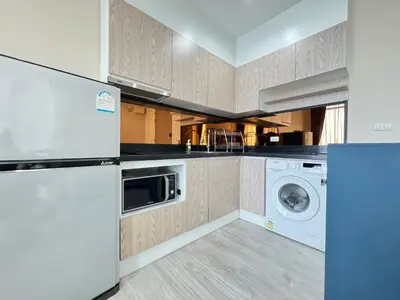 a kitchen with a refrigerator and a washer and dryer at Ekkamai Bangkok Condo in Bangkok