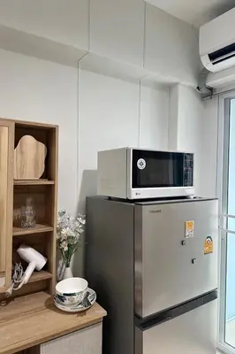 a microwave on top of a refrigerator in a kitchen at City View Condo 5 mins to MRT Sutthisarn in Bangkok