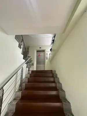a staircase in a building with brown stairs and a door at City View Condo 5 mins to MRT Sutthisarn in Bangkok