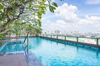 a swimming pool on top of a building with a city at Warm&Cozy Stay near BTS Thonglor in Bangkok