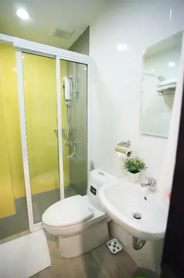 a bathroom with a shower and a toilet and a sink at SU 22 in Bangkok