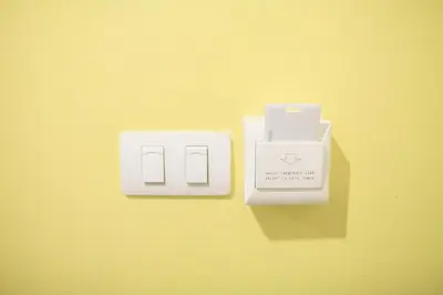 a couple of electrical switches on a yellow wall at SU 22 in Bangkok