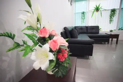 a living room with a couch and a table with flowers at SU 22 in Bangkok