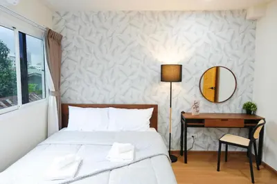 a bedroom with a bed and a desk and a mirror at Deluxe Gam-Hom Hostel เจริญนคร in Bangkok