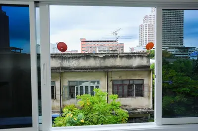 a window view of an old building with two red balloons at Deluxe Gam-Hom Hostel เจริญนคร in Bangkok