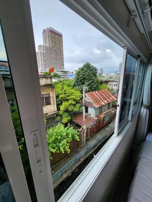 a window in a room with a view of a city at Deluxe Gam-Hom Hostel เจริญนคร in Bangkok