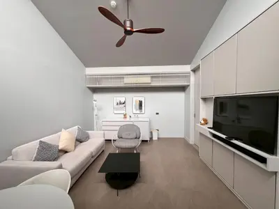 a living room with a couch and a ceiling fan at Tree Villa Bangkok in Bangkok