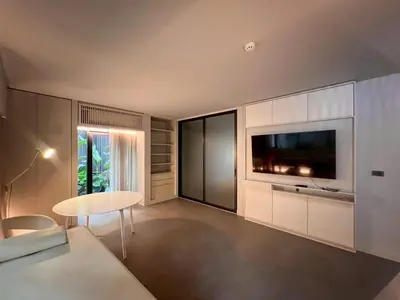 a living room with a television and a table at Tree Villa Bangkok in Bangkok