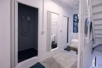 a white bathroom with a sink and a mirror at LCT Hostel Bangkok in Bangkok