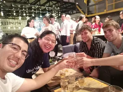 a group of people sitting at a table drinking wine at LCT Hostel Bangkok in Bangkok