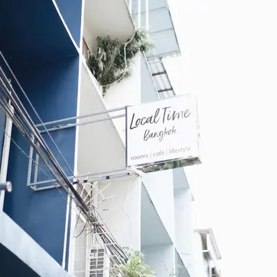 a sign on the side of a building with plants at LCT Hostel Bangkok in Bangkok