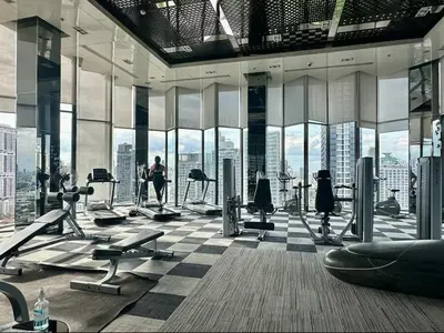 a gym with a view of a city at Thonglor Next to BTS Modern Condo - Fitness gym with full view in Bangkok