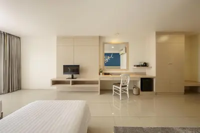 a bedroom with a bed and a desk with a television at Aspira Petchkasem in Ban Khlong Om Noi