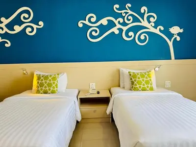 two beds in a room with a blue wall at Aspira Petchkasem in Ban Khlong Om Noi