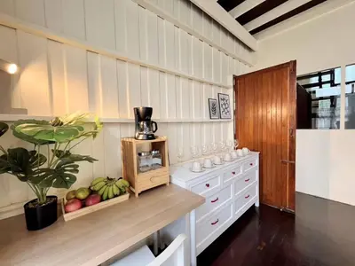 a kitchen with white cabinets and a table with fruit at Rare Find 80 yrs Heritage Peaceful House in BKK in Bangkok Yai
