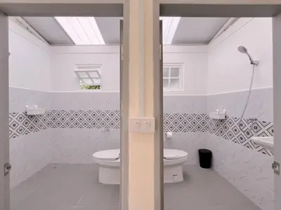 a white bathroom with a toilet and a sink at Rare Find 80 yrs Heritage Peaceful House in BKK in Bangkok Yai