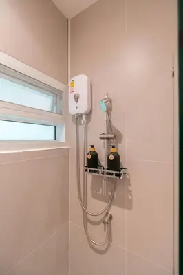 a shower in a bathroom with a shower head at Minimal House Maximum Happiness in Thung Maha Mek