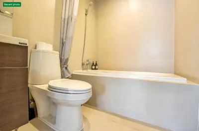 a bathroom with a toilet and a bath tub at Noble Remix Thonglor - Direct BTS Access - Super Fast Wi-Fi in Bangkok