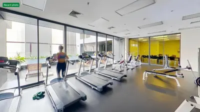 a woman standing in a gym with cardio machines at Noble Remix Thonglor - Direct BTS Access - Super Fast Wi-Fi in Bangkok