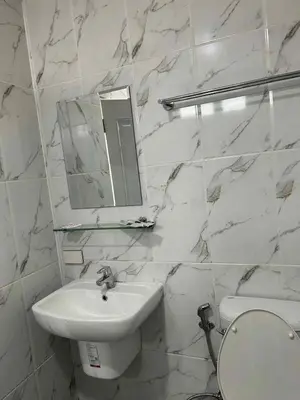 a white bathroom with a sink and a mirror at 101Hotel in Bangkok