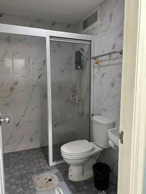 a bathroom with a toilet and a glass shower at 101Hotel in Bangkok