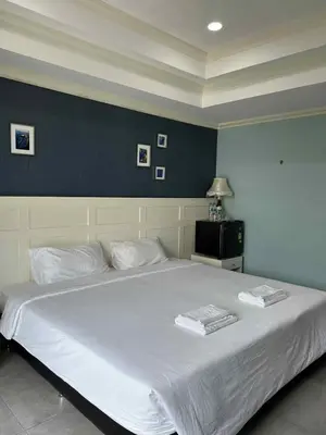a large white bed in a bedroom with a blue wall at 101Hotel in Bangkok