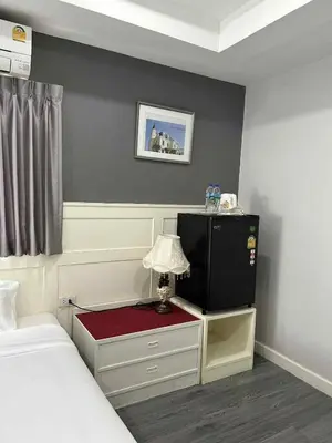 a bedroom with a bed and a small table with a lamp at 101Hotel in Bangkok