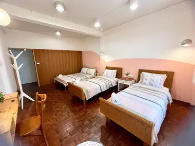 a hotel room with two beds and a table at Anne & Tan Stylist Homestay in Bangkok