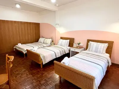 a hotel room with two beds and a chair at Anne & Tan Stylist Homestay in Bangkok