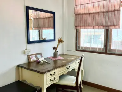 a desk in a room with a chair and a mirror at Anne & Tan Stylist Homestay in Bangkok
