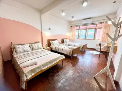 a bedroom with two beds and a couch and a table at Anne & Tan Stylist Homestay in Bangkok
