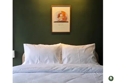 a bedroom with a white bed with a green wall at Obahomu Vacation House for 4-8 pax, 5 min walk to Icon Siam in Bangkok