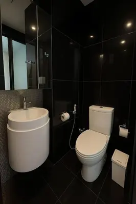 a bathroom with a white toilet and a sink at Peaceful Stylish and cozy condo in Khlong Toei