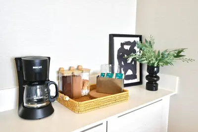 a coffee maker sitting on a counter next to a vase at 5min Metro | KingBed | Kitchen full | Netflix WiFi in Khlong Toei
