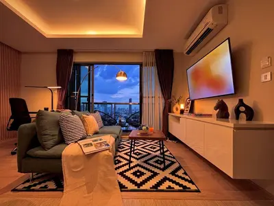 a living room with a couch and a flat screen tv at 5min Metro | KingBed | Kitchen full | Netflix WiFi in Khlong Toei